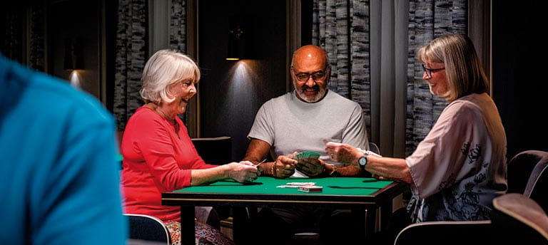 People enjoying a game in the Card Room on Spirit of Adventure